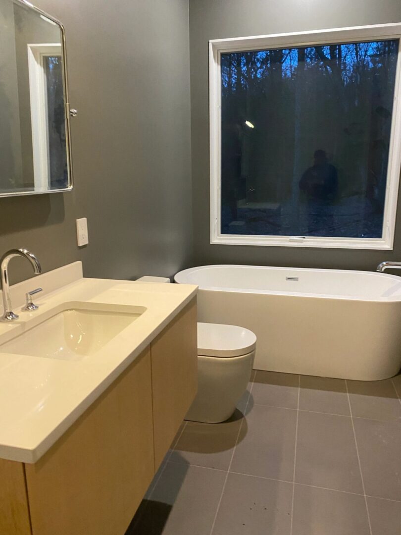 A bathroom with a sink, toilet and bathtub.